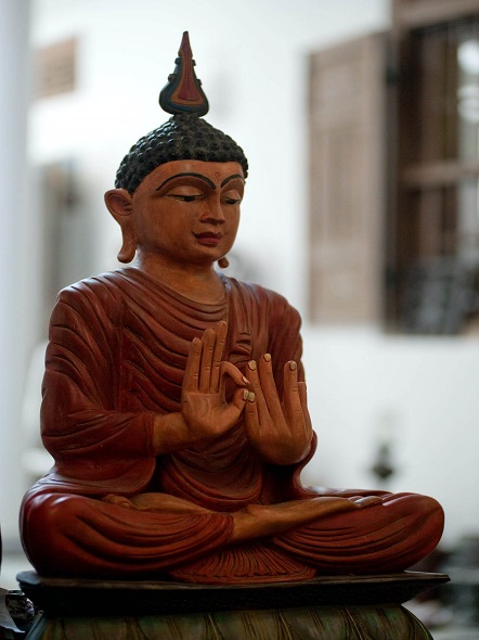 scultura in legno di un buddha in meditazione